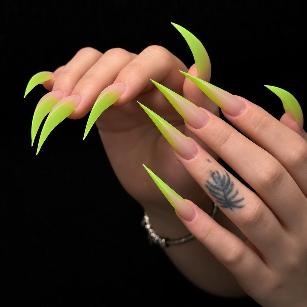 Close-up of lime green ombre Dragon Claw press-on nails with extra long pointed tips, shown holding a green plush toy.